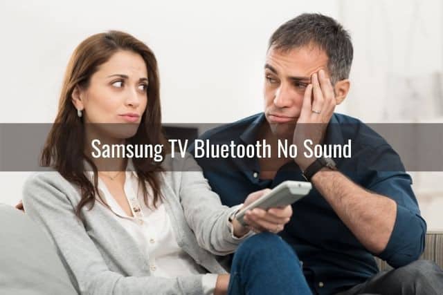 Man looking at woman confused why TV remote is not working