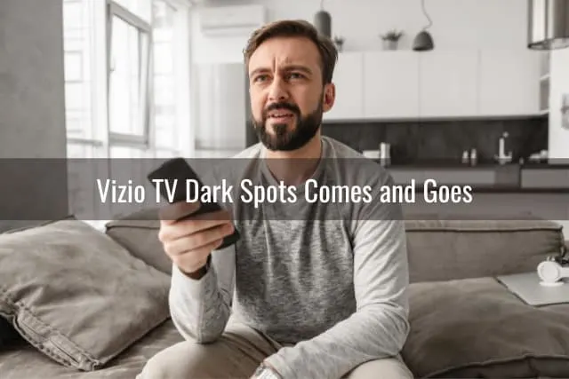 confused man holding a remote while watching tv