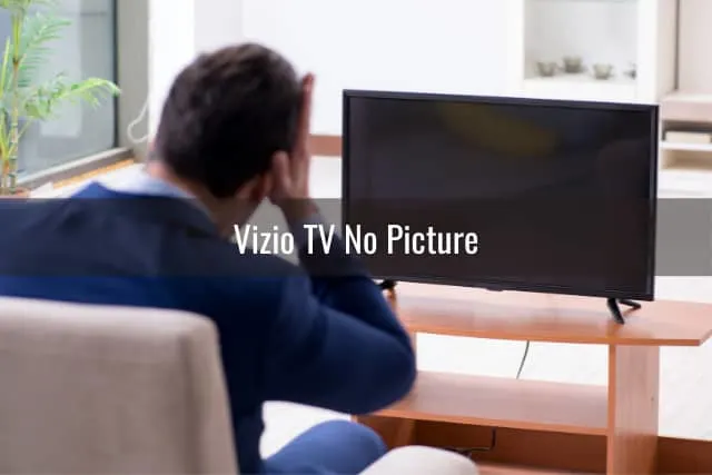 Frustrated man looking at the blank screen tv