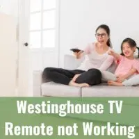 Mother and daughter watching tv while holding a remote