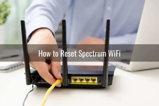 Guy plugging yellow ethernet cord to back of router