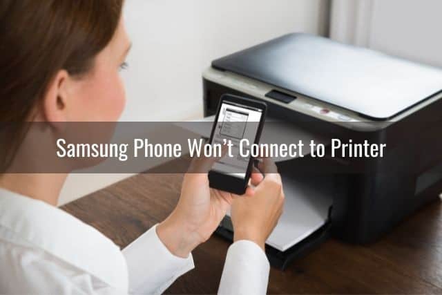 Person using phone with printer in background