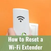 Hand plugging in WiFi Extender into wall socket