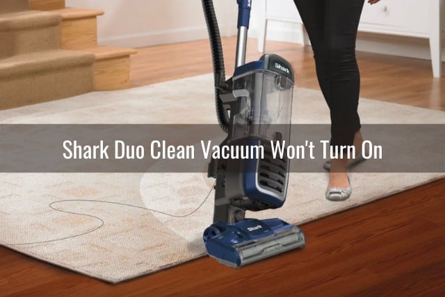Woman cleaning the floor using vacuum