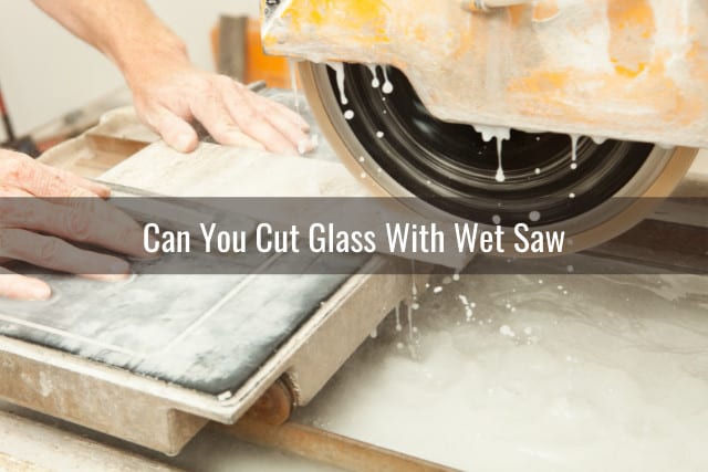 Man cutting the glass using wet saw