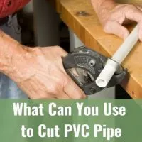 Plumber using pipe cutter to trim PVC pipe