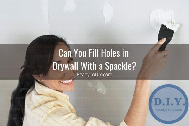 Woman fixing drywall with spackle
