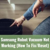 Finger pushing power button on robot vacuum