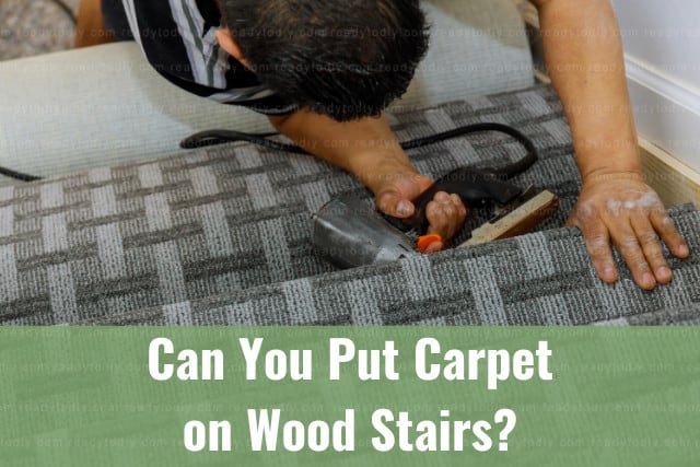Man installing carpet in wood stairs