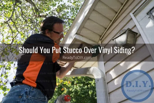 Man cleaning vinyl siding house